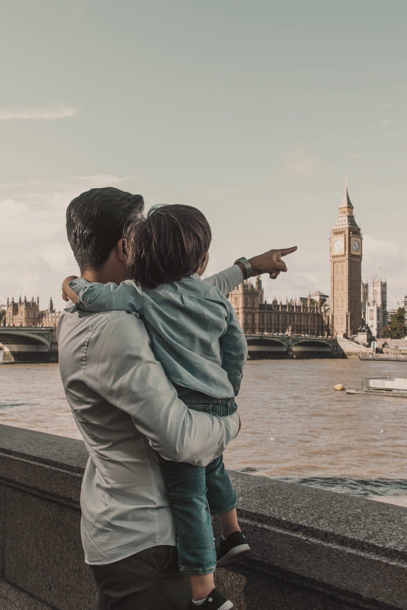 A father and son looking at Big Ben across the Thames
